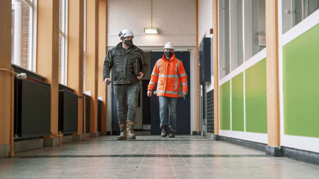 Twee medewerkers lopen door Schoonhovens College voor het inspecteren van afvalstromen