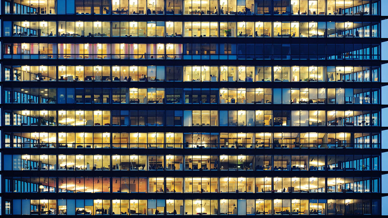 Vooraanzicht van kantoorpand met verlichte kantoren