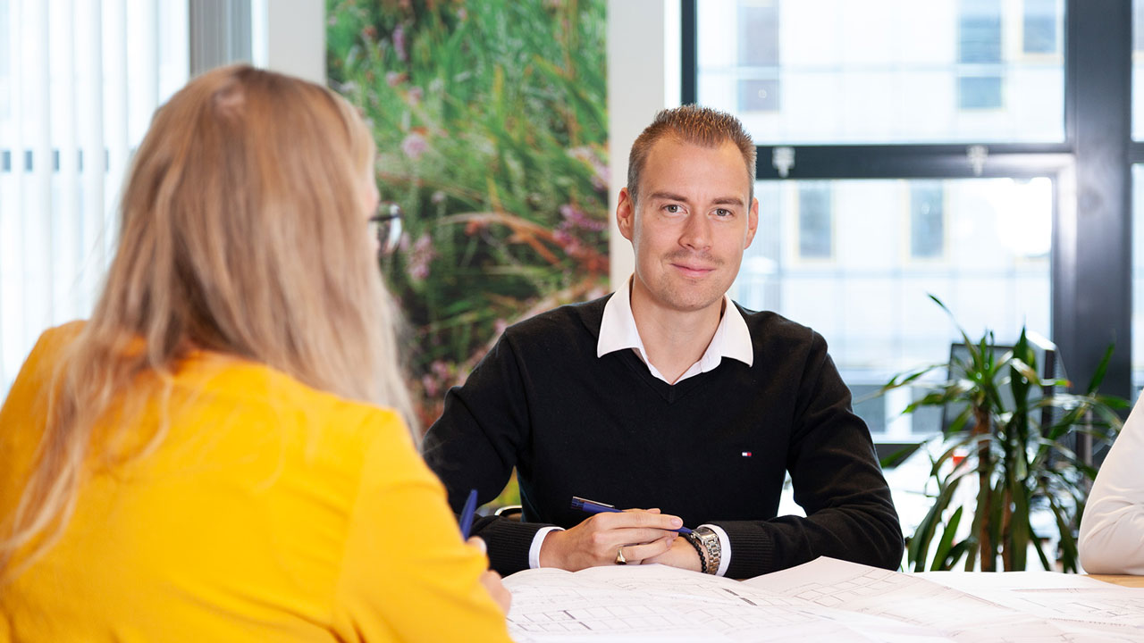 Vastgoed adviseur aan tafel met tekening voor zich