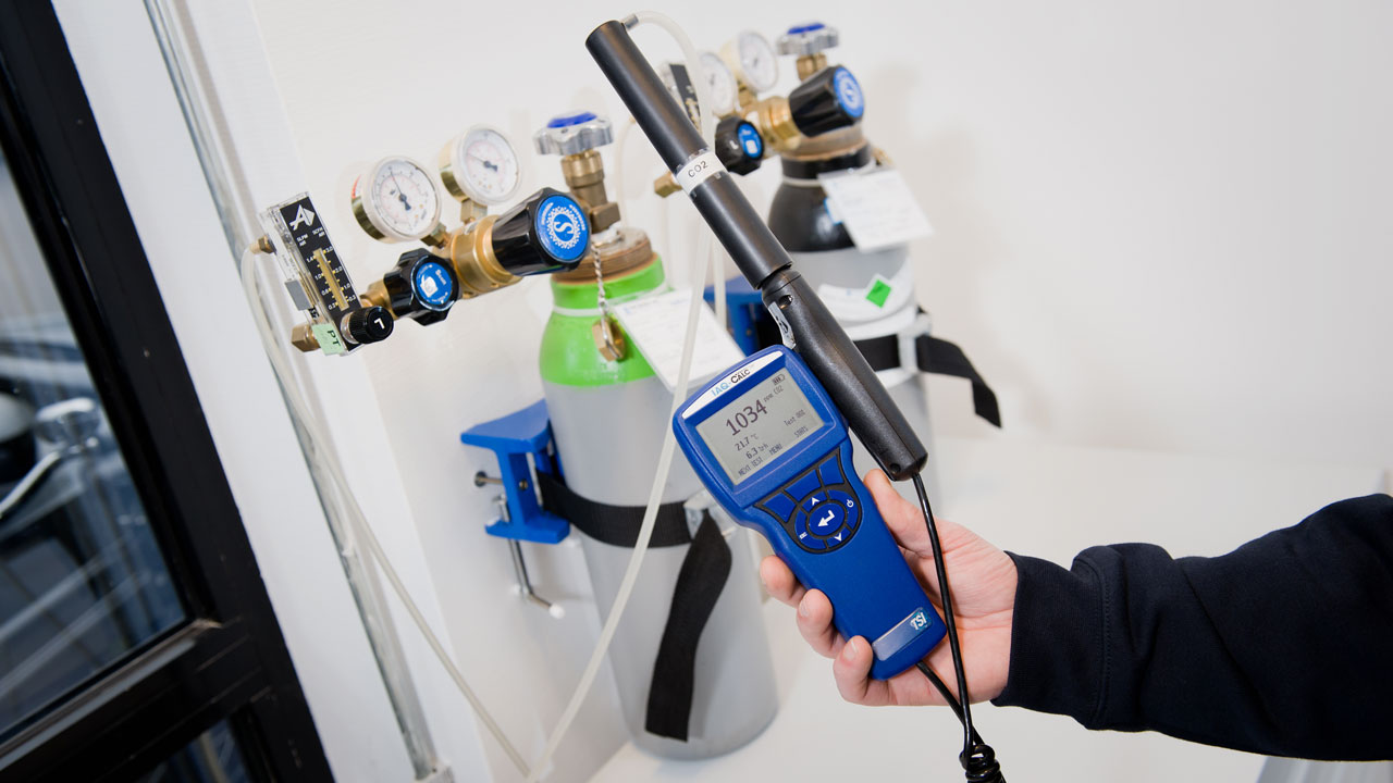 Arbeidshygiënist toont handheld CO₂-meter voor luchtkwaliteitsmetingen