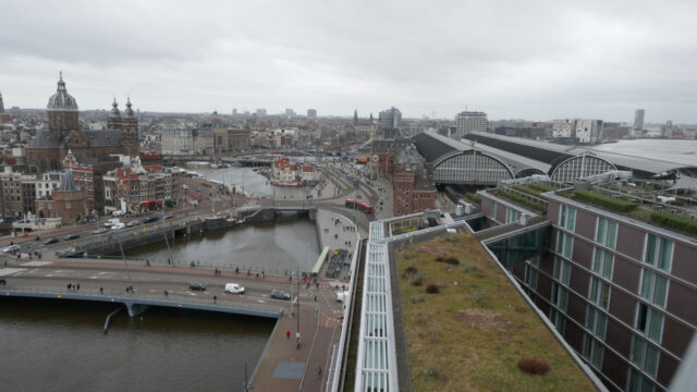 Stadsgezicht met rivier, bruggen en moderne en historische gebouwen, waaronder een kerk en een vervoersknooppunt