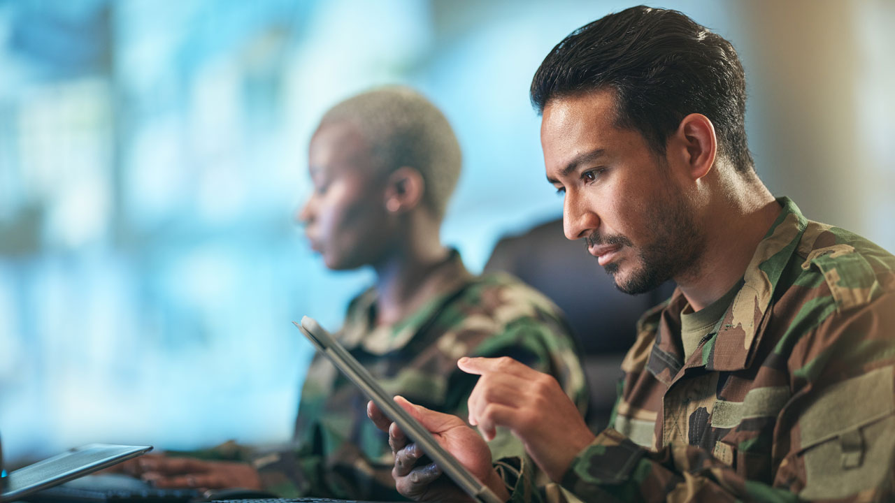 Defensie medewerkers aan bureau op tablet
