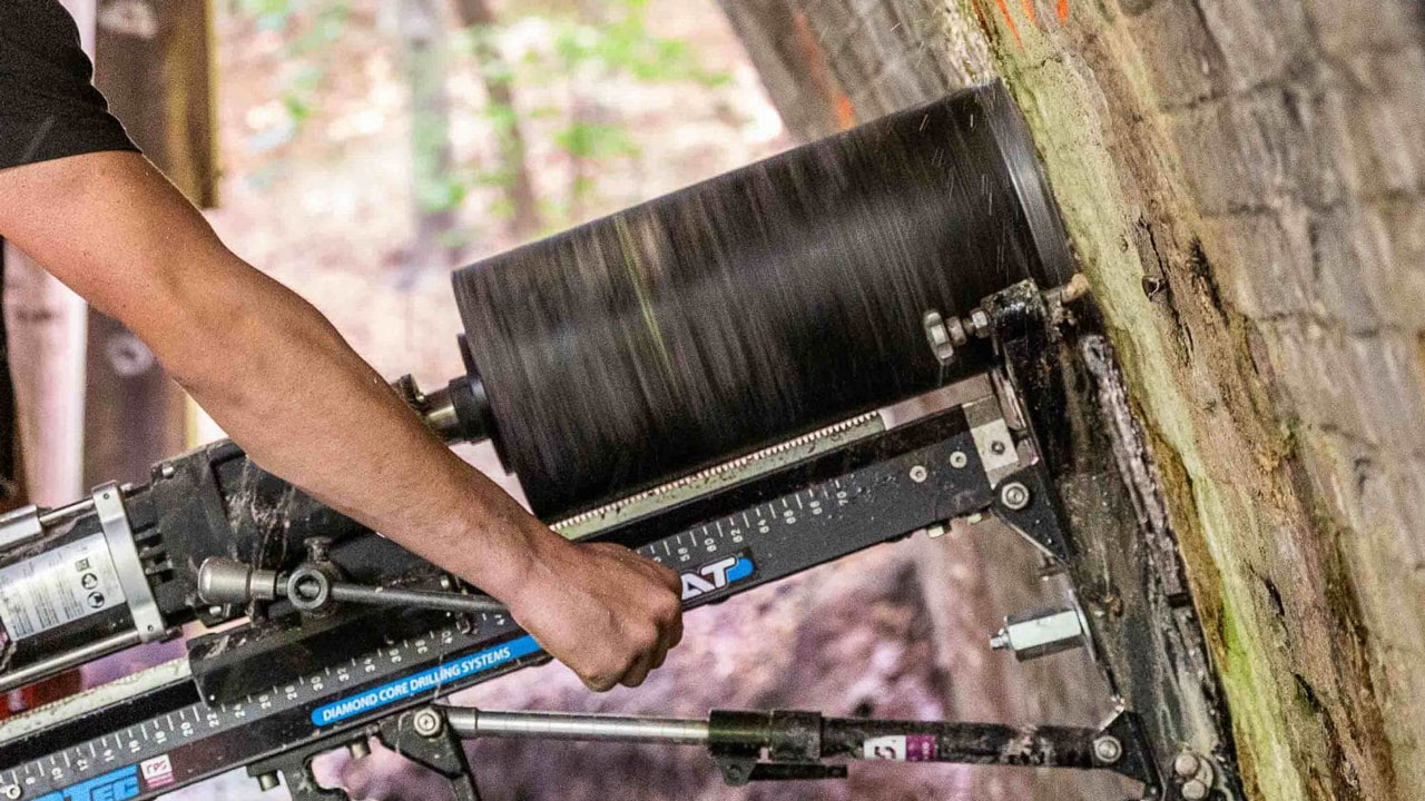 Kernboorinstallatie in gebruik tegen bakstenen muur voor materiaalonderzoek, met draaiende boorkop van DIATEC-systeem