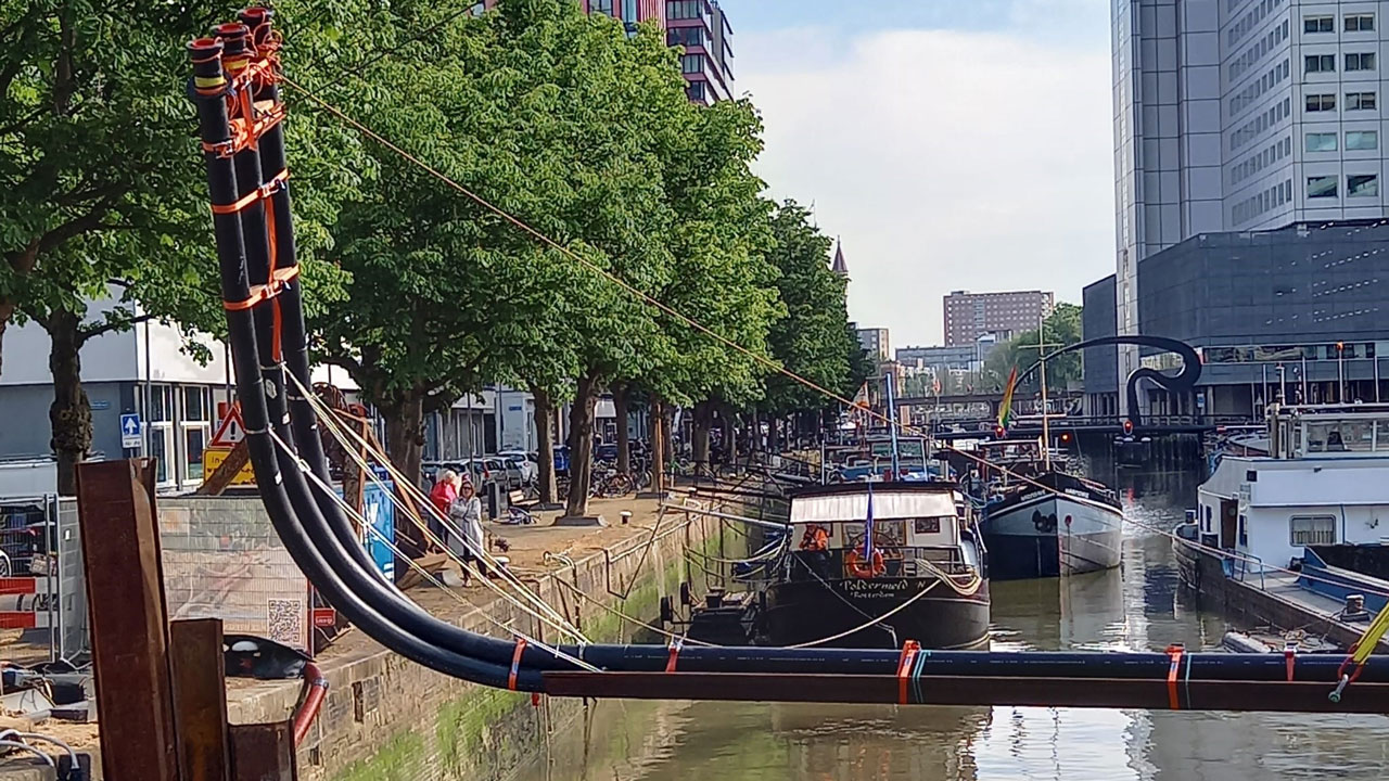 Kanaal met aangelegde leidingen boven water in stedelijke omgeving, onderdeel van tracé-engineering en infrastructuurontwikkeling