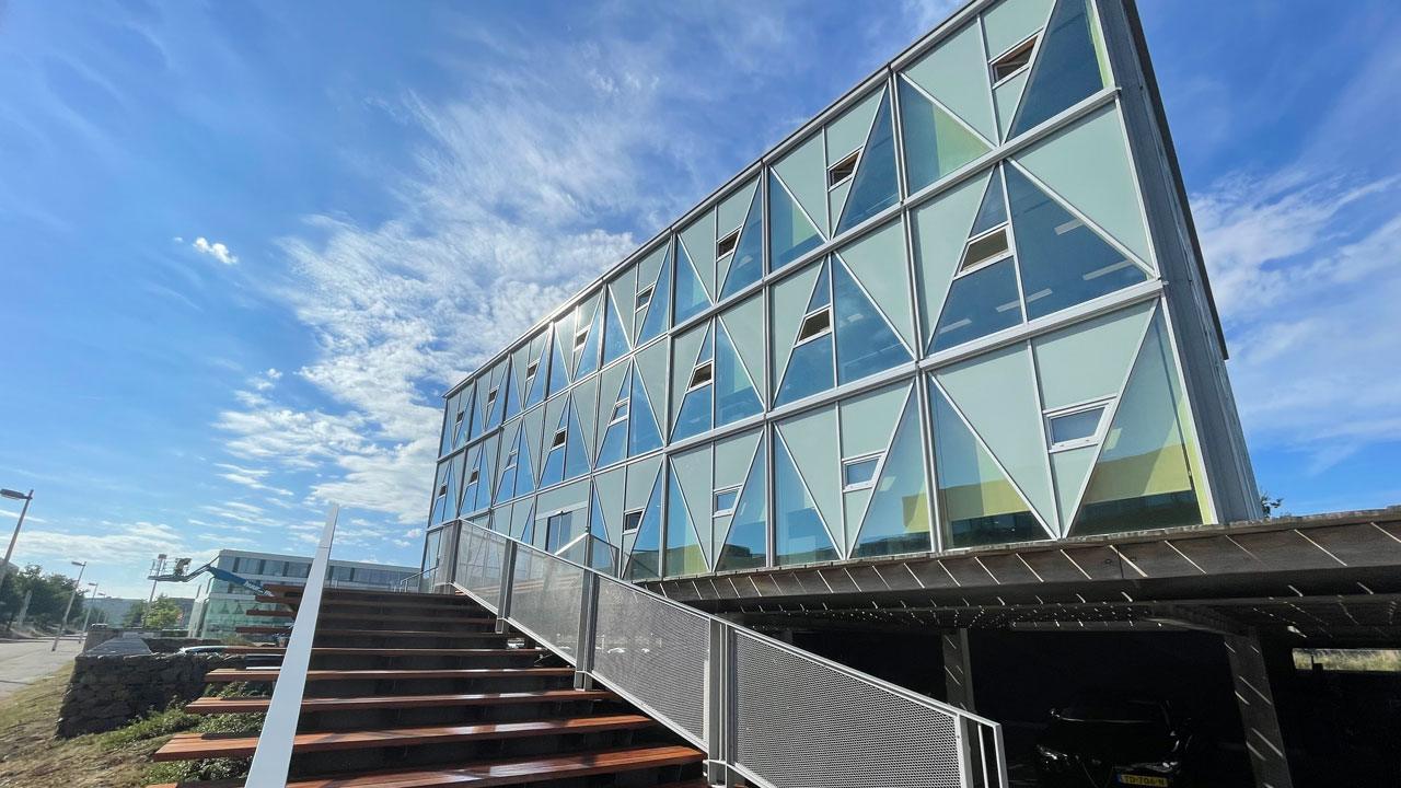 Modern gebouw met glazen gevel en trap naar entree, relevant voor inspectie en inventarisatie van vastgoedobjecten