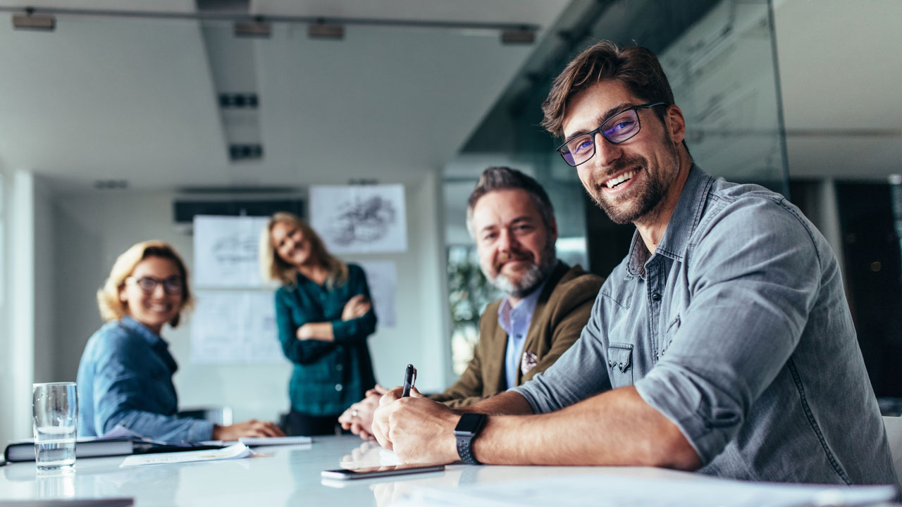 Overleg over vergunningen in kantoorruimte met documenten en visualisaties op de achtergrond