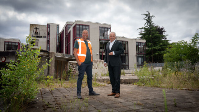Twee mannen voor een oud schoolgebouw