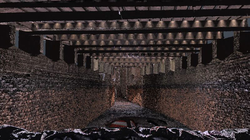 Ondergrondse tunnel met bakstenen wanden en dwarsbalken, geschikt voor 3D-laserscanning van complexe of historische structuren