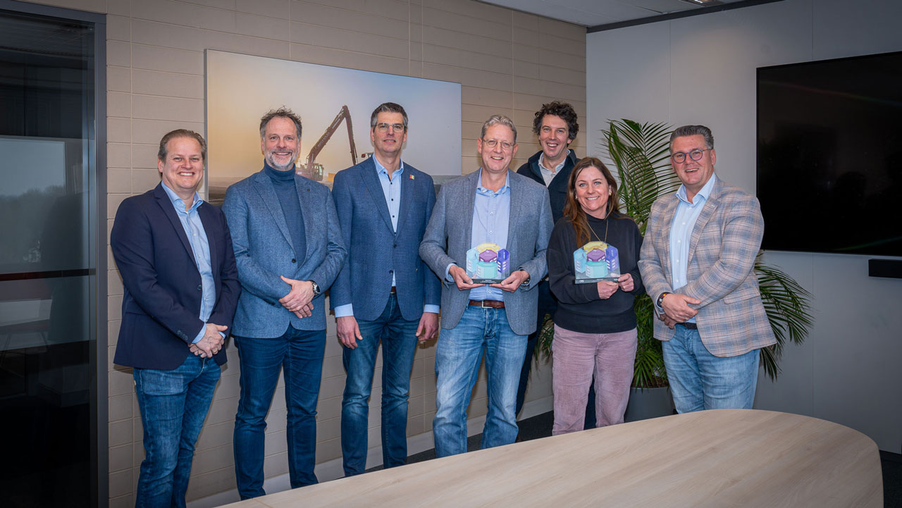 Groep met twee awardwinnaars in kantooromgeving ter erkenning voor veiligheidsprestaties bij BAM en Heijmans