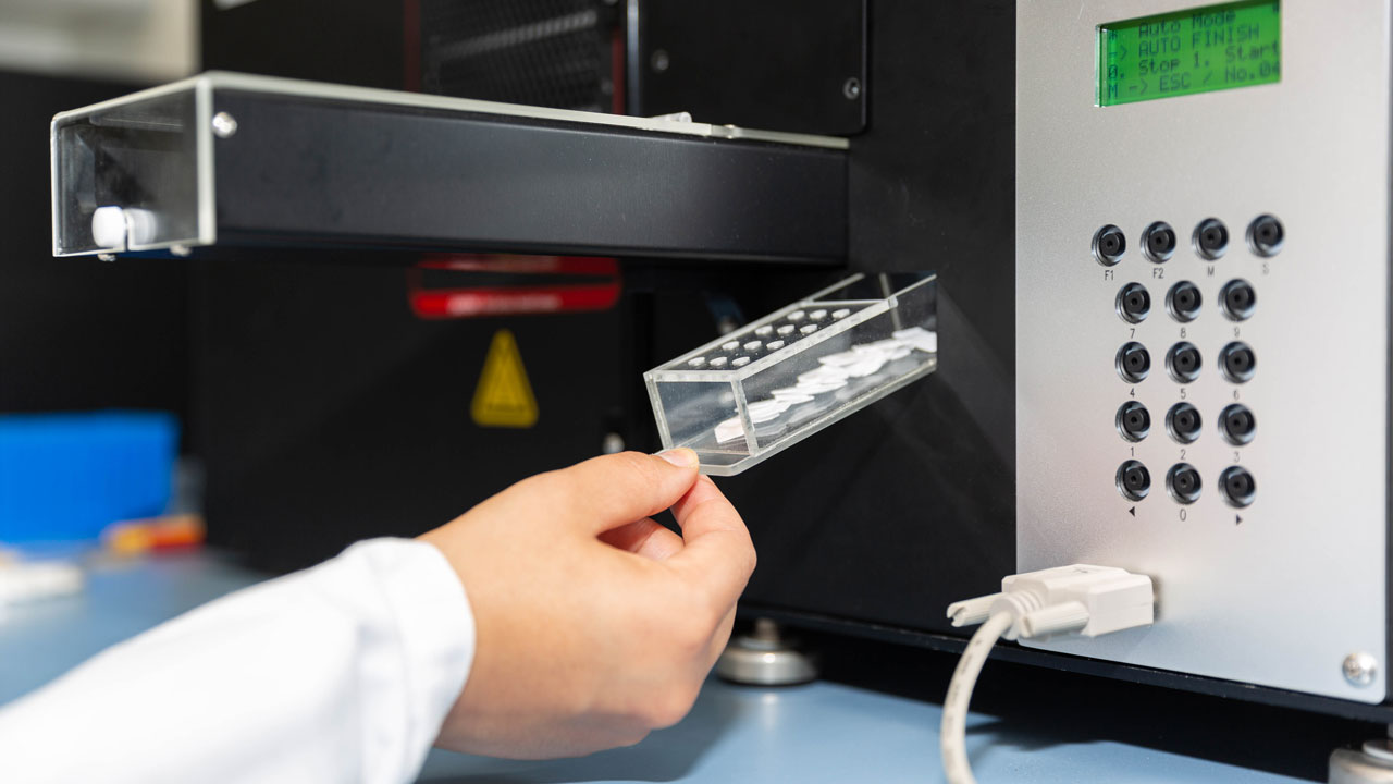 Labmedewerker plaatst monsters in analyseapparaat – blackbox-technologie voor nauwkeurige dieselrookmeting en emissieonderzoek