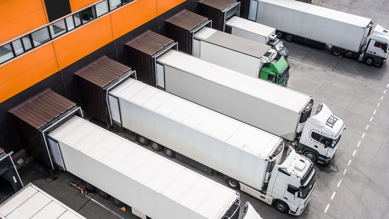 Luchtfoto van vrachtwagens bij laadperron – monitoring van dieselrookemissie met blackbox-technologie voor schonere logistiek