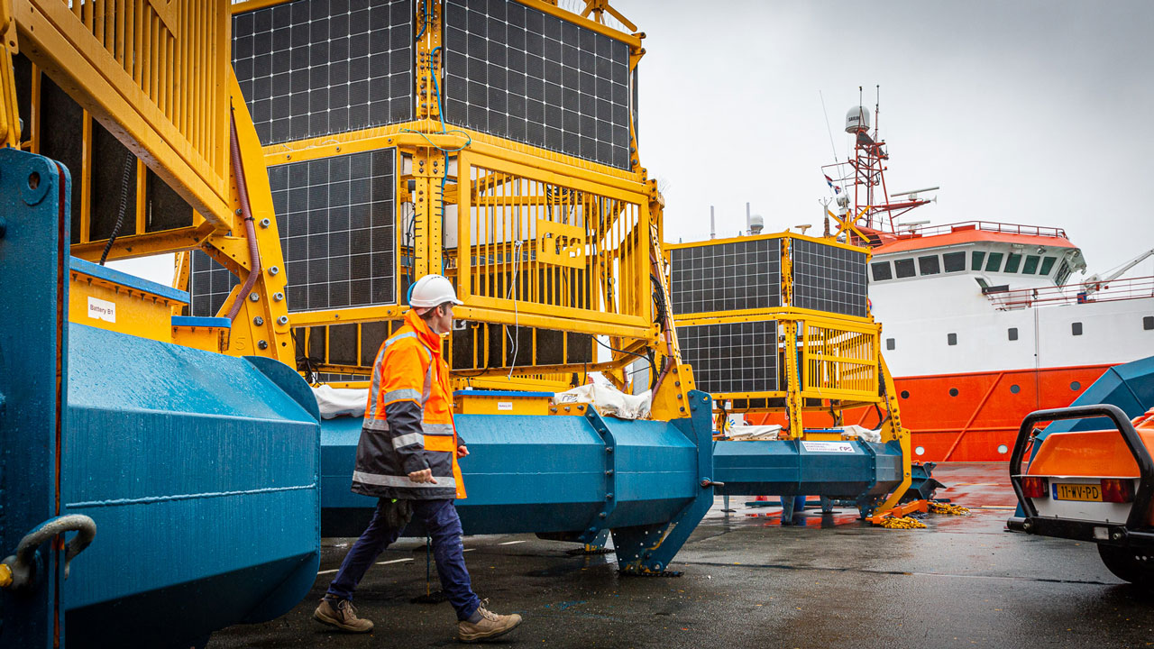 Medewerker op dok bij LiDAR-boeien voor metingen van wind, golven, stroming en getijden in innovatief Noordzeeproject