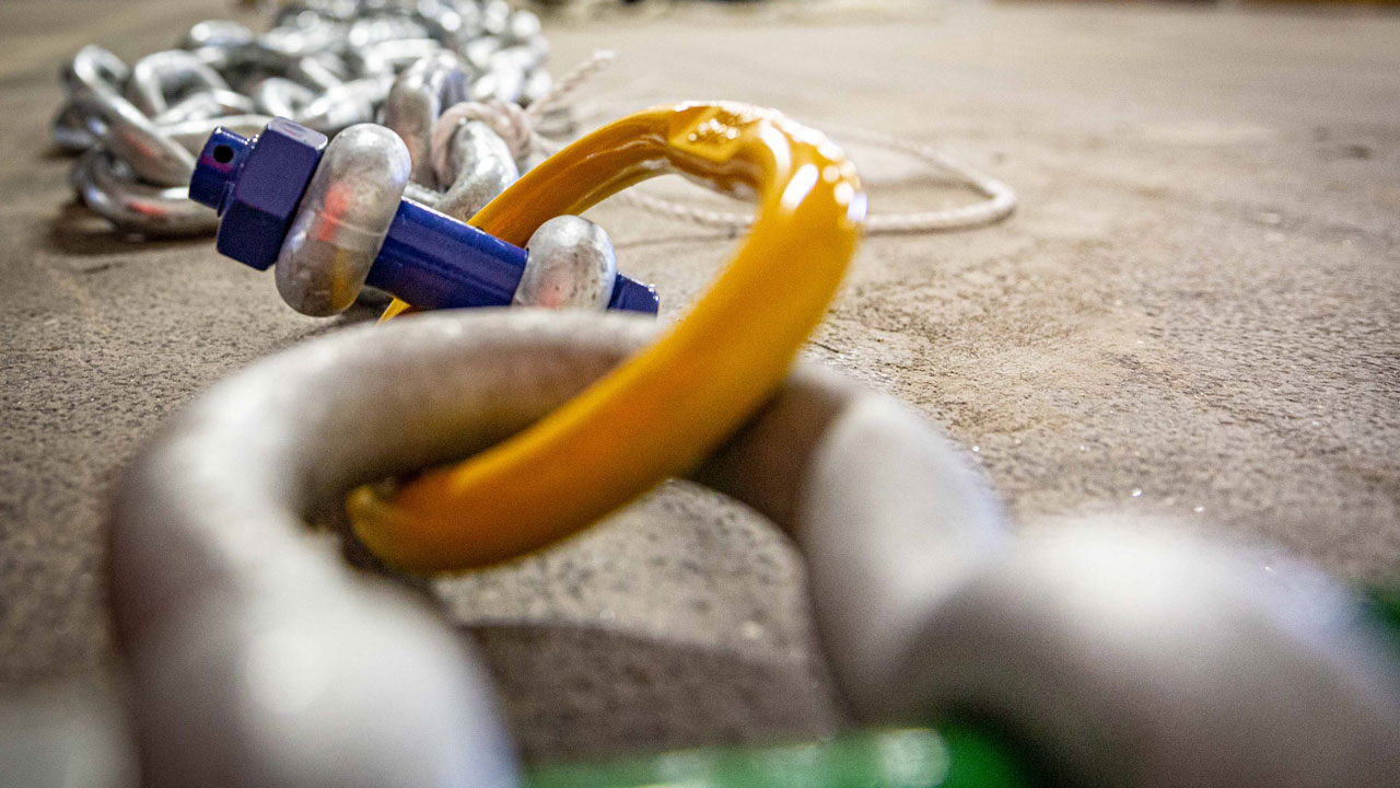 Detail van ankerketting met gele en blauwe componenten, essentieel voor verankering van LiDAR-boeien op de Noordzee