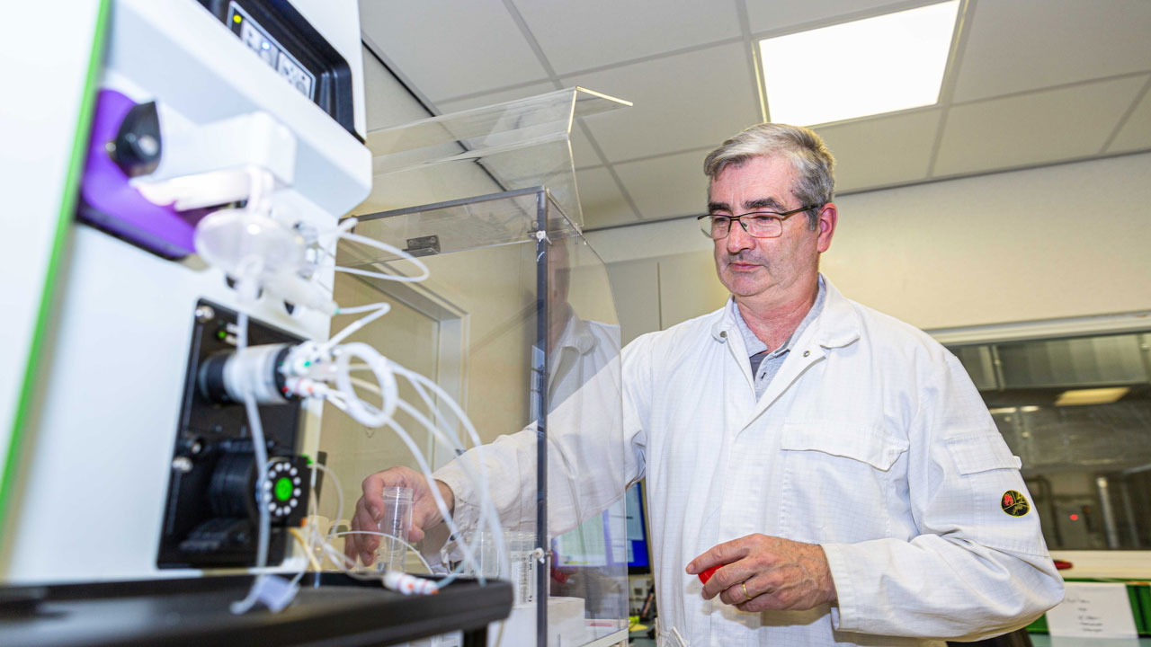 Laborant in witte jas aan het werk in laboratorium, illustratie van 20 jaar expertise en toewijding in Limburg