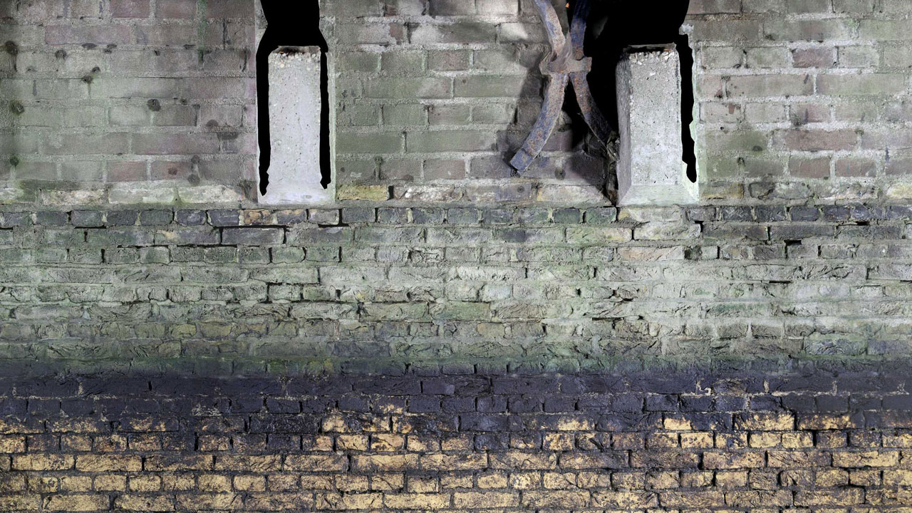 Verweerde bakstenen muur met openingen, geïnspecteerd tijdens drietrapsaanpak voor waterveiligheid bij molens door Tetra Tech
