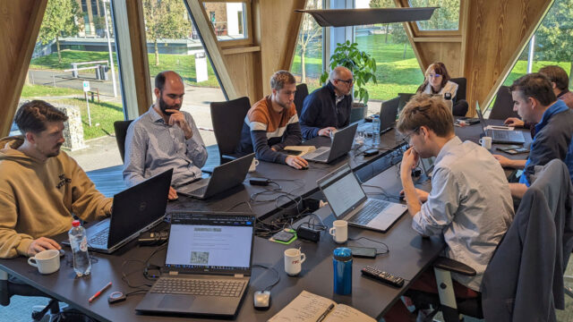 Team werkt met laptops in lichte vergaderruimte, illustratie van samenwerking en digitale workflows met ArcGIS Pro in een moderne kantooromgeving