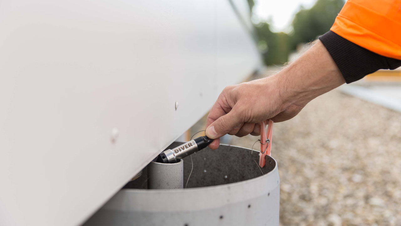 Onderzoeker plaatst DIVER-meetinstrument in veldsituatie, onderdeel van monitoring groene daken voor gemeente Utrecht
