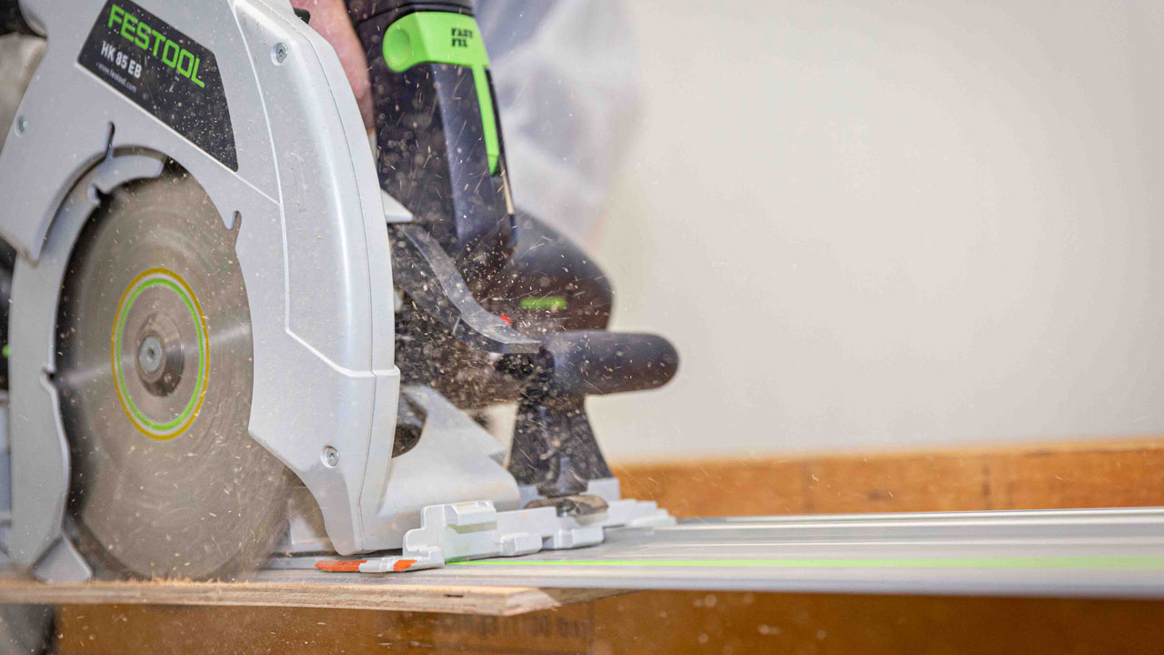 Close-up van Festool HK 85 zaag in actie op bouwplaats, illustratie van stofarm werken met professioneel gereedschap