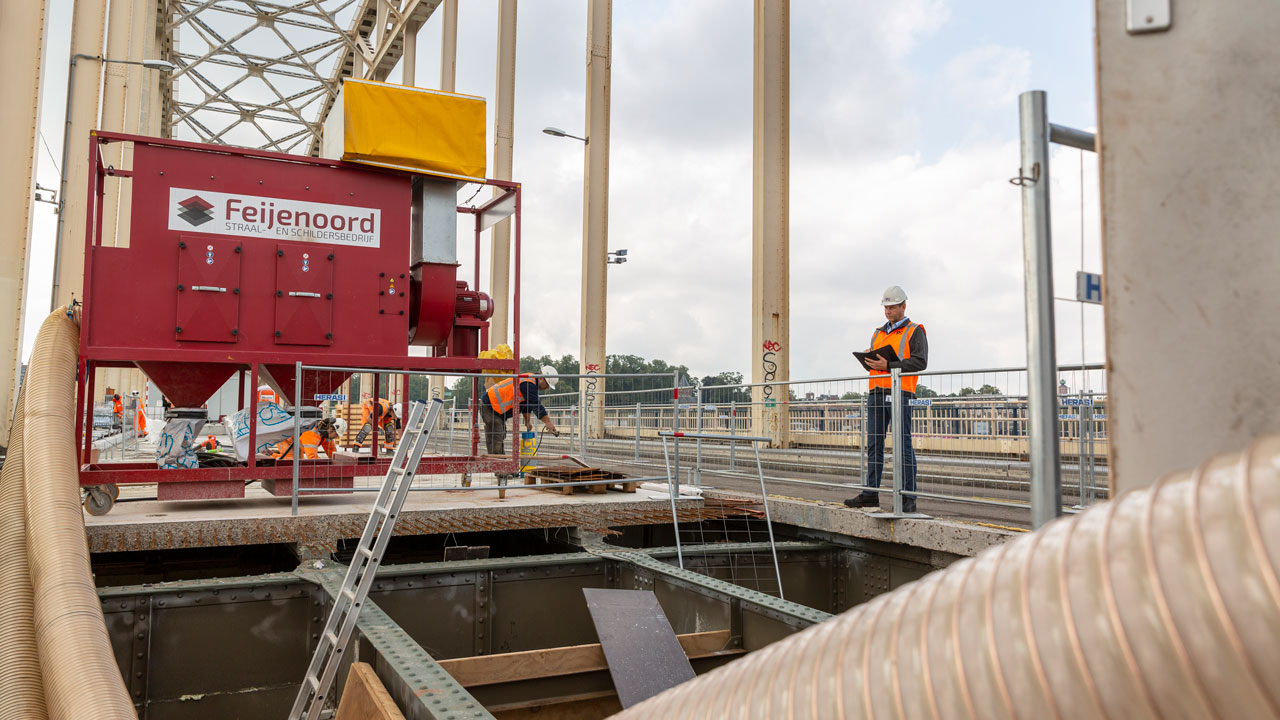 Sanering chroom-6 op brug door Tetra Tech met Feijenoord-machine, veiligheidskleding en materieel zichtbaar op civiel werkterrein