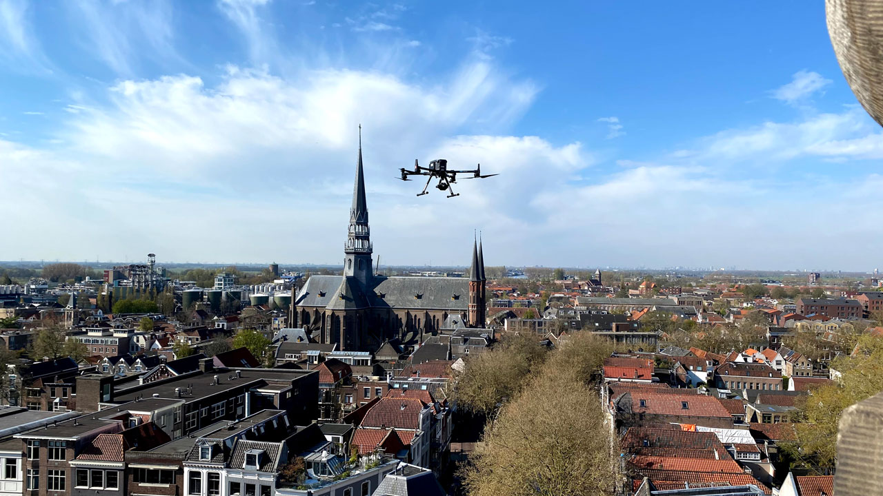 Drone-inspectie metselwerk: luchtfoto van stad met kerktoren, gebruikt voor het opsporen van scheuren in historische gevels