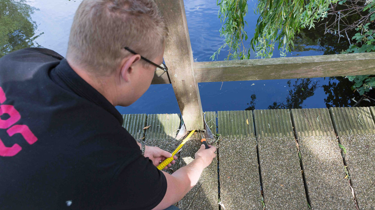 Specialist verricht metingen bij brug