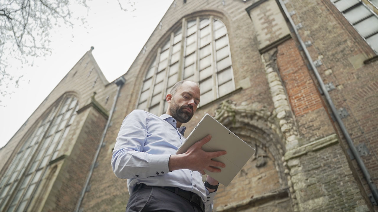 Inspectie van historisch gebouw met tablet en AI voor het opsporen van scheuren in metselwerk en gevels