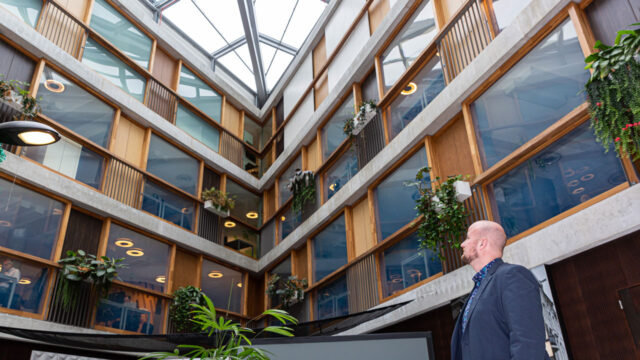 Strategische labels als vliegwiel voor vastgoedbeheer in modern kantoorgebouw met glazen dak en groene planten