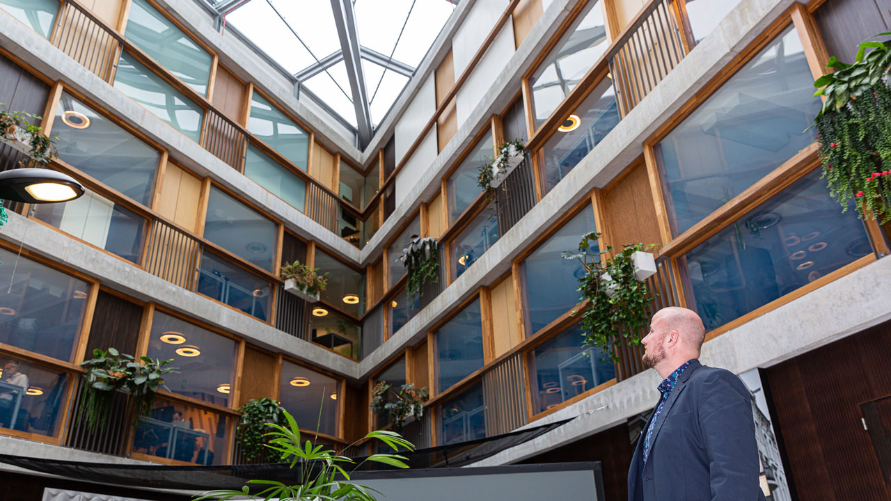 Strategische labels als vliegwiel voor vastgoedbeheer in modern kantoorgebouw met glazen dak en groene planten