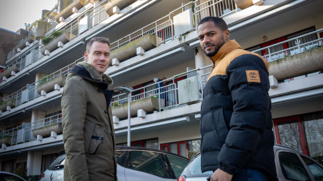 Twee mannen staan voor een woningcomplex