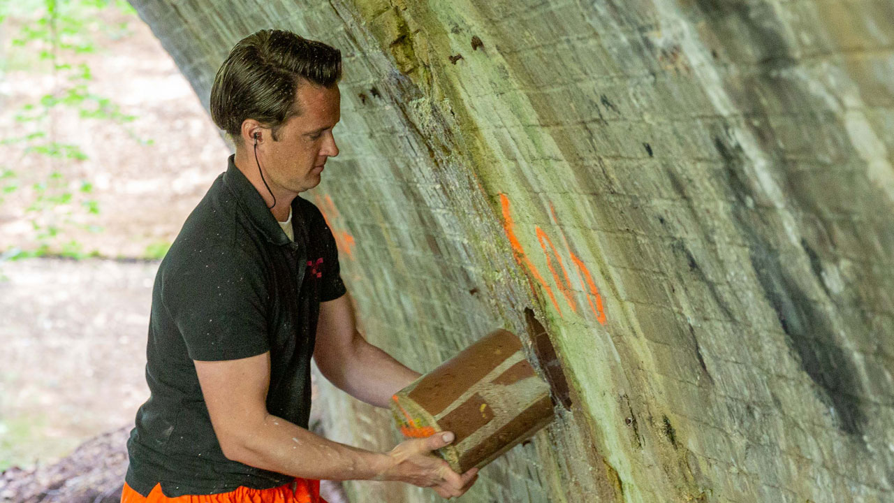 Boorkern wordt uit muur verwijdert voor analyse en onderzoek