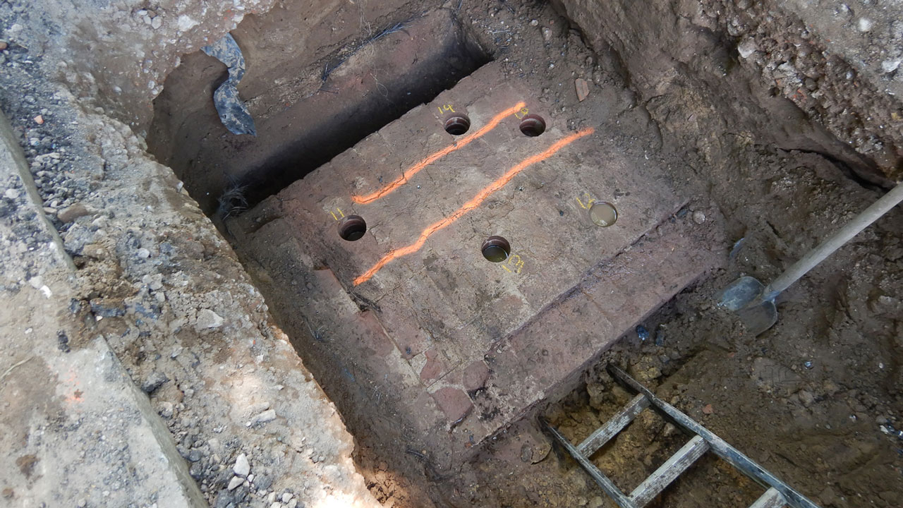 Inspectieput met betonnen plaat en boorgaten bij boogbrug Naarden, onderdeel van Tetra Tech-onderzoek aan rijksmonumentale constructie