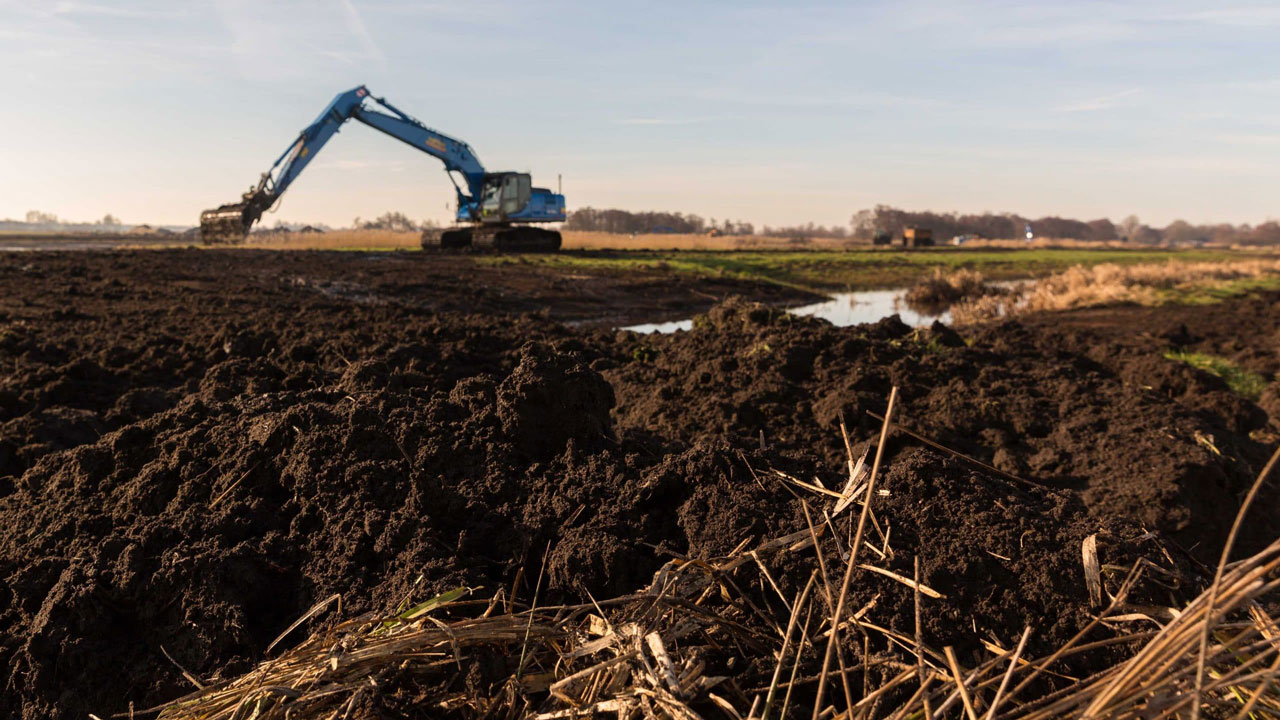 Blauwe graafmachine aan het werk in natuurgebied tijdens werkzaamheden voor herstelmaatregelen in de Oostelijke Vechtplassen