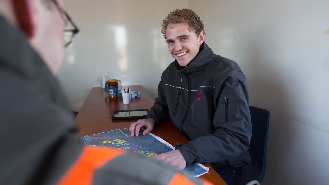 Overleg aan tafel met kaart en tablet over natuurherstel in Oostelijke Vechtplassen, samenwerking tussen experts in het veld