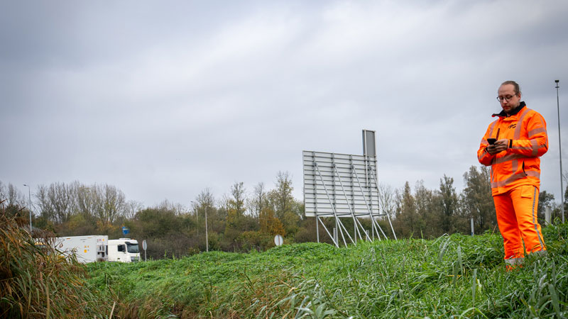 Tetra Tech-medewerker onderzoekt flora langs snelweg bij watergang: ecologische zorg tussen asfalt en natuur in beeld