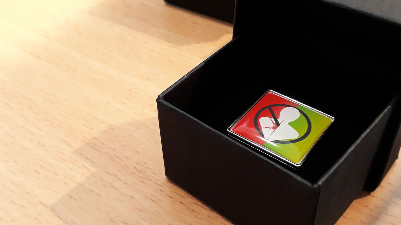 Speldje van Opgelucht-campagne met symbool tegen beroepsziekten, focus op gezonde werkomgeving en preventie – Tetra Tech initiatie