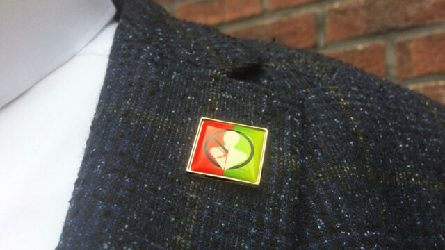 Speldje op jasje symboliseert aandacht voor beroepsziekten, gezondheid en veiligheid op de werkvloer – Tetra Tech campagnebeeld