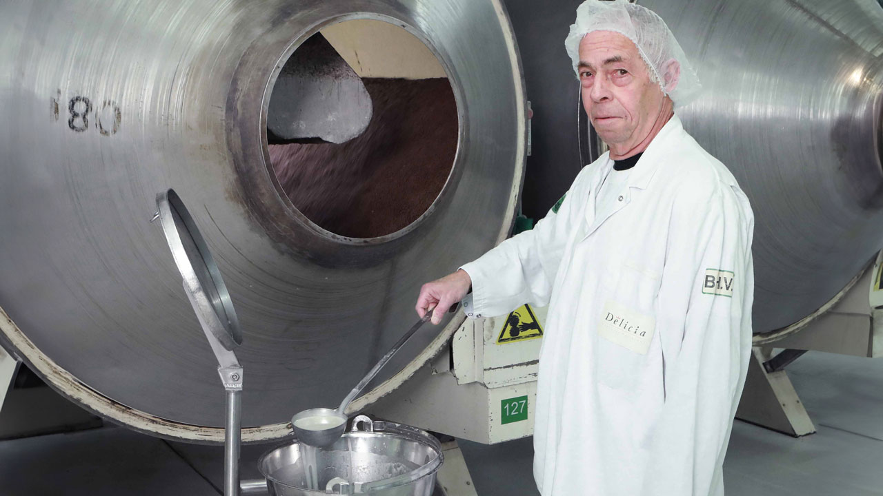 Medewerker in labjas werkt met industriële apparatuur – illustratie bij artikel over arbosysteem en risico’s op beroepsziekten