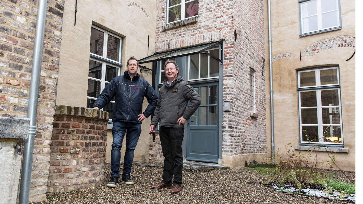 Twee personen in binnenplaats van oude fabriek, verkennen locatie voor asbestonderzoek in de Puddingfabriek
