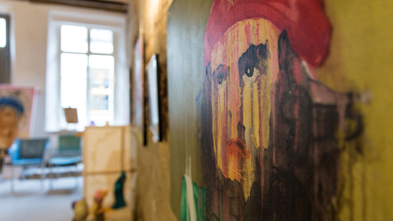 Muurschildering in voormalige fabriek toont persoon met rode hoed