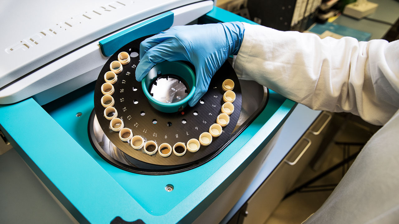 Laboratoriummedewerker plaatst monster in centrifuge voor analyse van formaldehyde in gecontroleerde omgeving