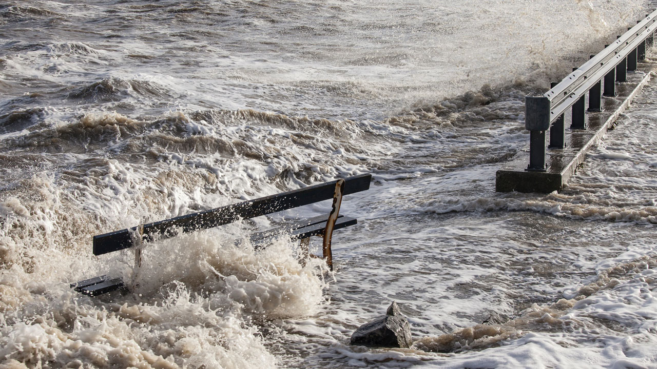 Hevige golfslag tegen beschadigde kade. Wij onderzoeken klimaateffecten zoals overstroming en waterdruk op stedelijke infrastructuur
