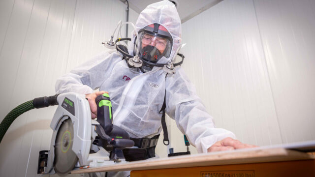 Stofvrij werken met beschermende kleding en afzuiging – veilig zagen op werkbank in testomgeving