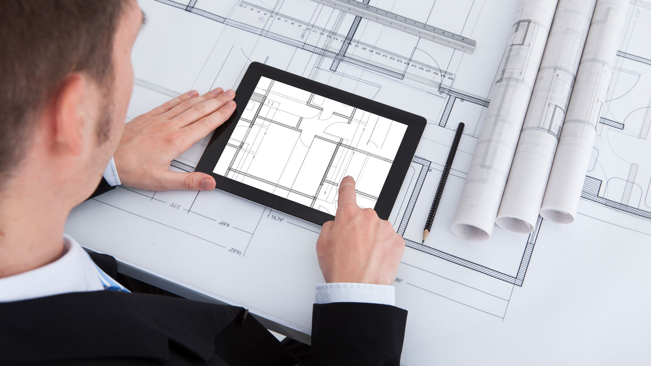 Man met tablet en bouwtekeningen, visualisatie van digitaal tekeningenbeheer en informatiemanagement in de bouwsector