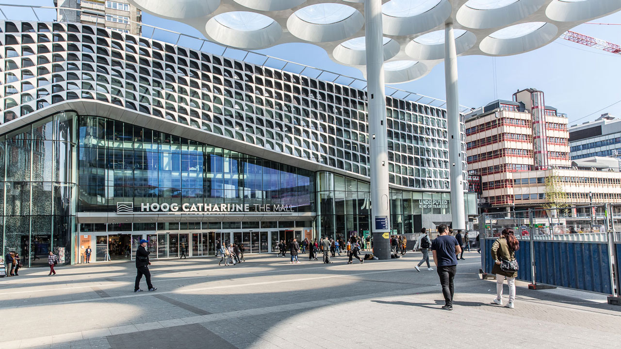 Voorzijde van Hoog Catharijne The Mall in Utrecht, locatie van asbestinventarisatie, met moderne gevel en winkelend publiek
