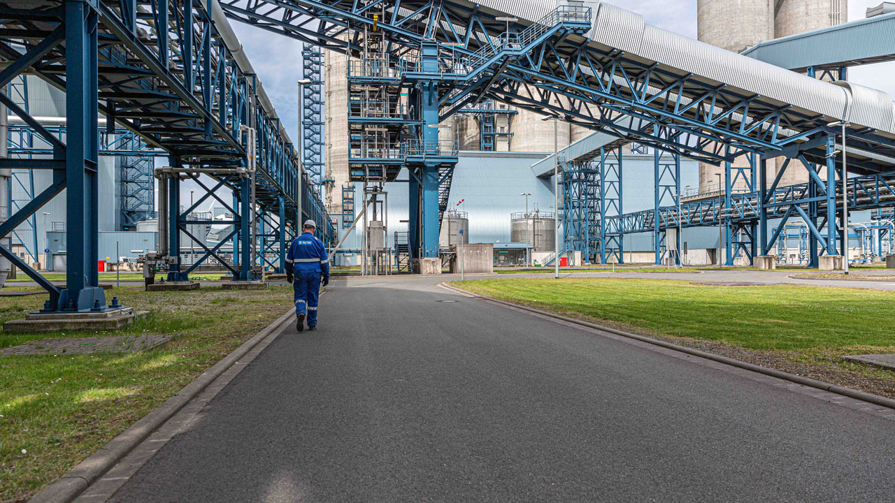 Industrieterrein met opslagtanks en transportbanden, illustratie van werkomgeving waar biomonitoring veiligheid bevordert