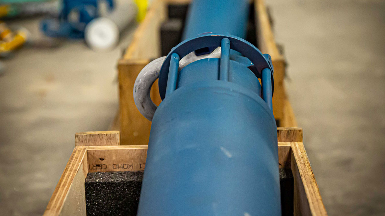 Blauw cilindrisch onderdeel in houten kist, onderdeel van LiDAR-boei voor windmetingen op zee binnen Tetra Tech-project Noordzee