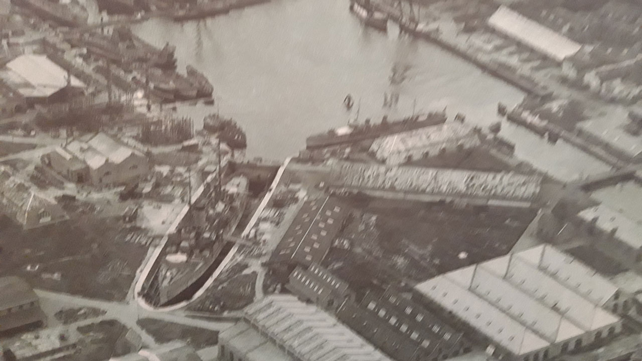 Historische luchtfoto van scheepswerf met dokken en schepen, illustratie van maritieme inspecties en onderhoudswerkzaamheden