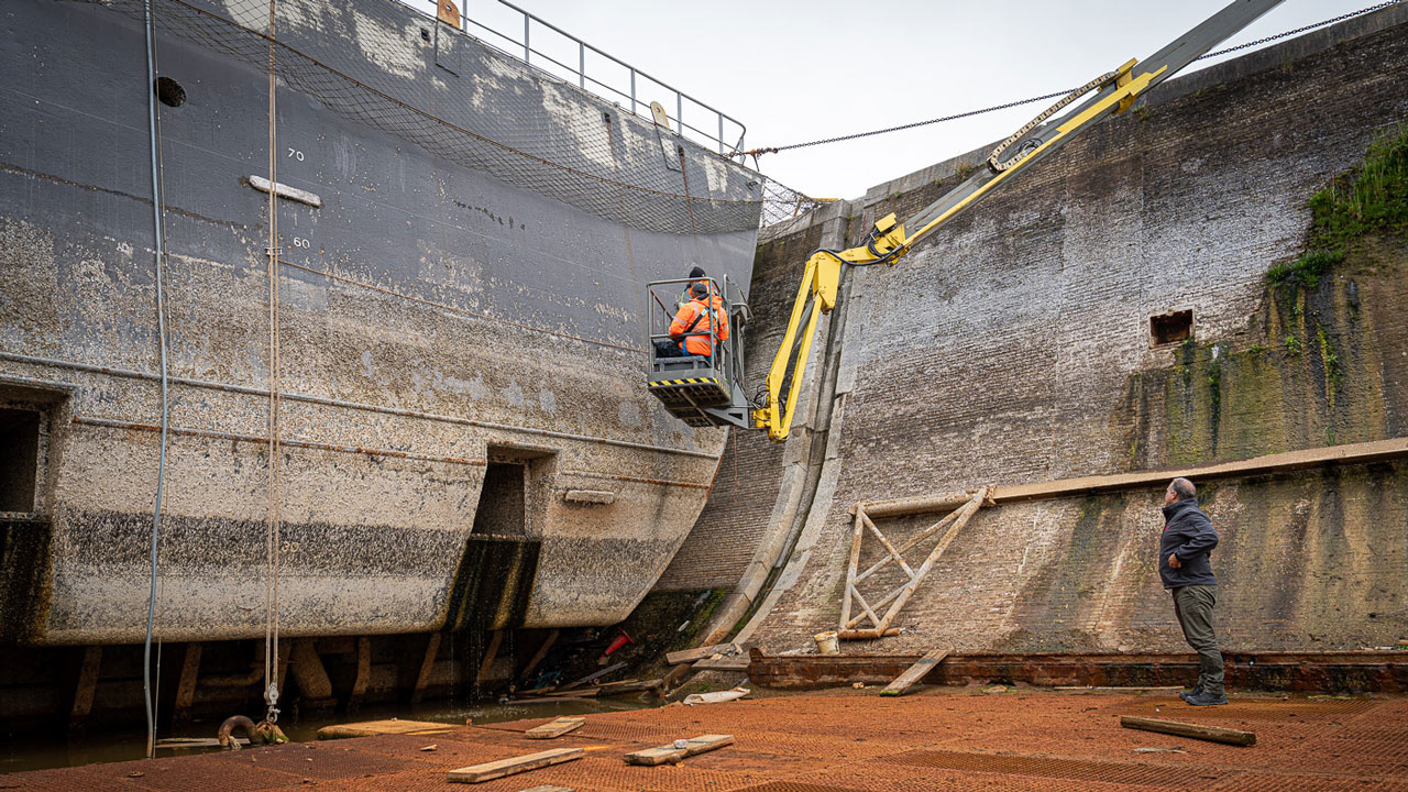 Inspectie van deuren in droogdok door medewerkers, onderdeel van maritiem onderzoek naar veiligheid en onderhoud droogdokdeuren