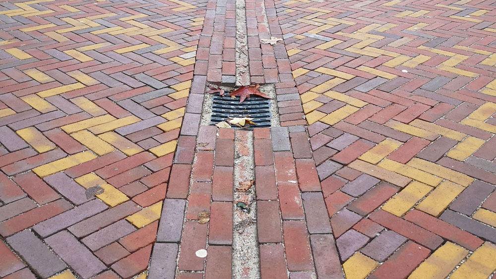 Herinrichting winkelcentrum De Meenthof met kleurrijke bestrating en afwatering, voor een aantrekkelijke openbare ruimte