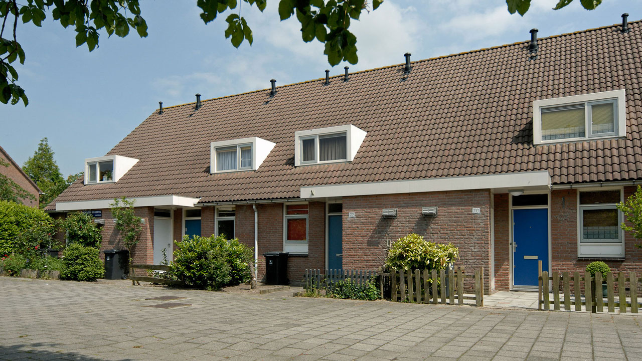 Rij eengezinswoningen met blauwe deuren en voortuinen, geïnspecteerd door Tetra Tech in het kader van woningonderhoud en bouwkundige keuringen
